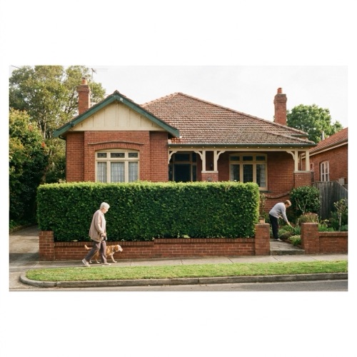 A brick home with a manicured hedge